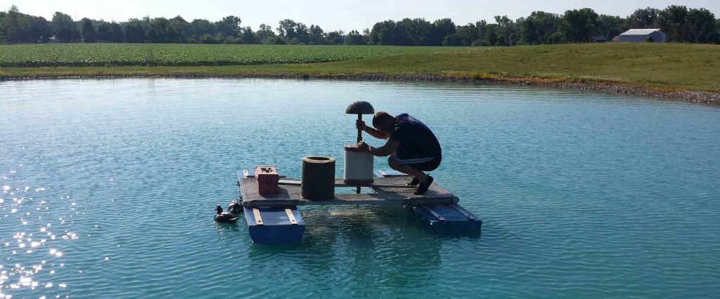 Aquatek Water Technician changing a pond filter for a customer who has a Pond Water Treatment System.